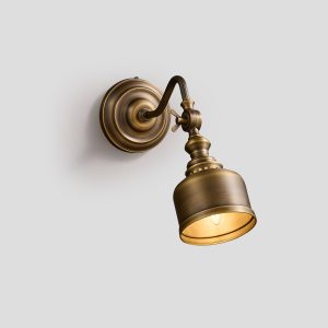 Elegant curved arm mid-century modern brass wall sconce in brushed finish, ideal for gallery or bedside lighting.