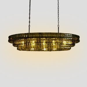 Modern tiered olive green glass pendant light with iron frame hanging over a dining table.