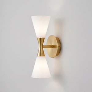 Mid-century modern 2-light hourglass wall sconce in brushed brass finish with frosted glass shades.